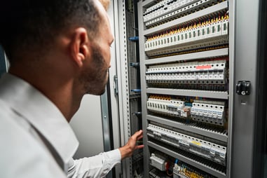 data-center-worker-reaching-for-electrical-switch